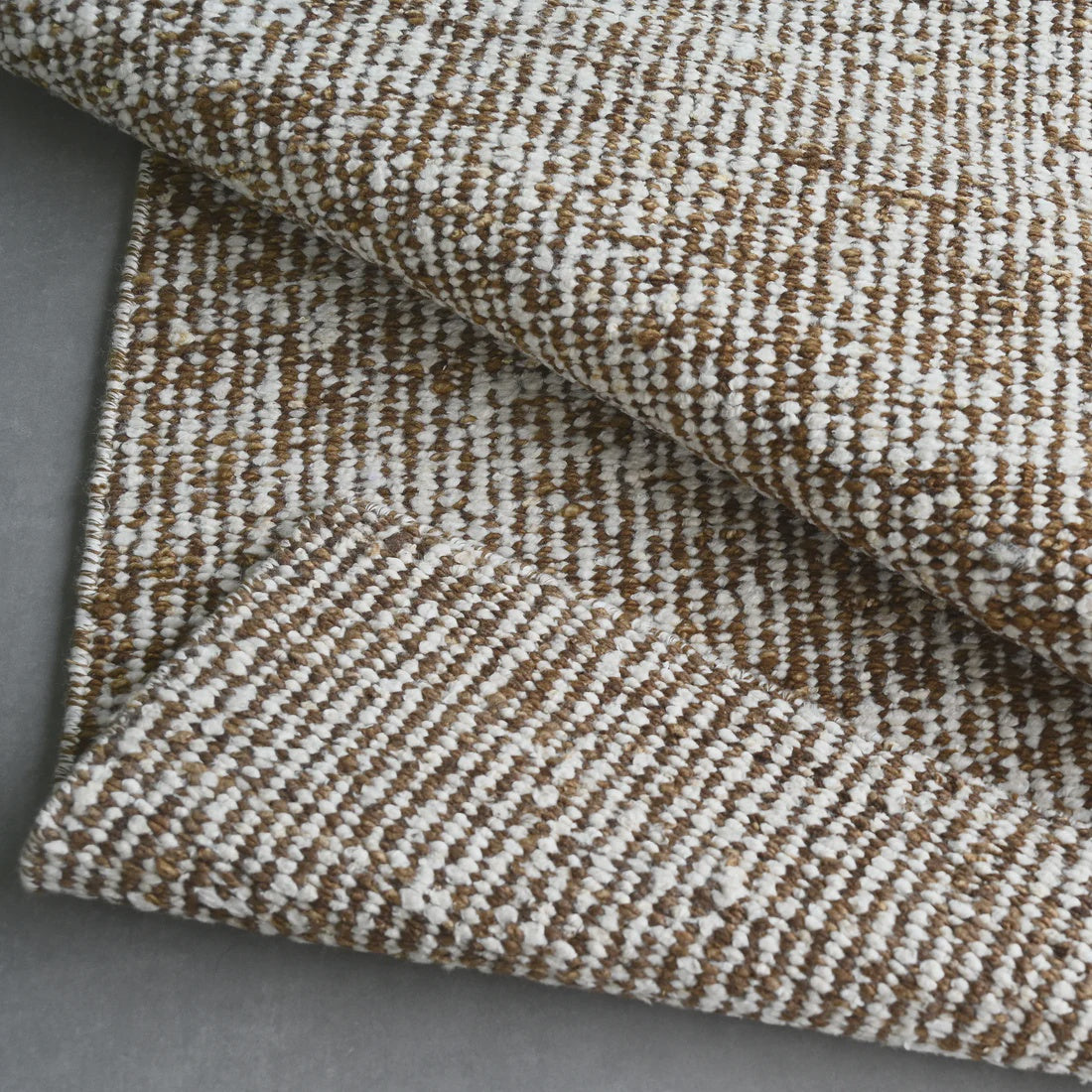 Close-up of a textured brown and beige fabric on a gray surface