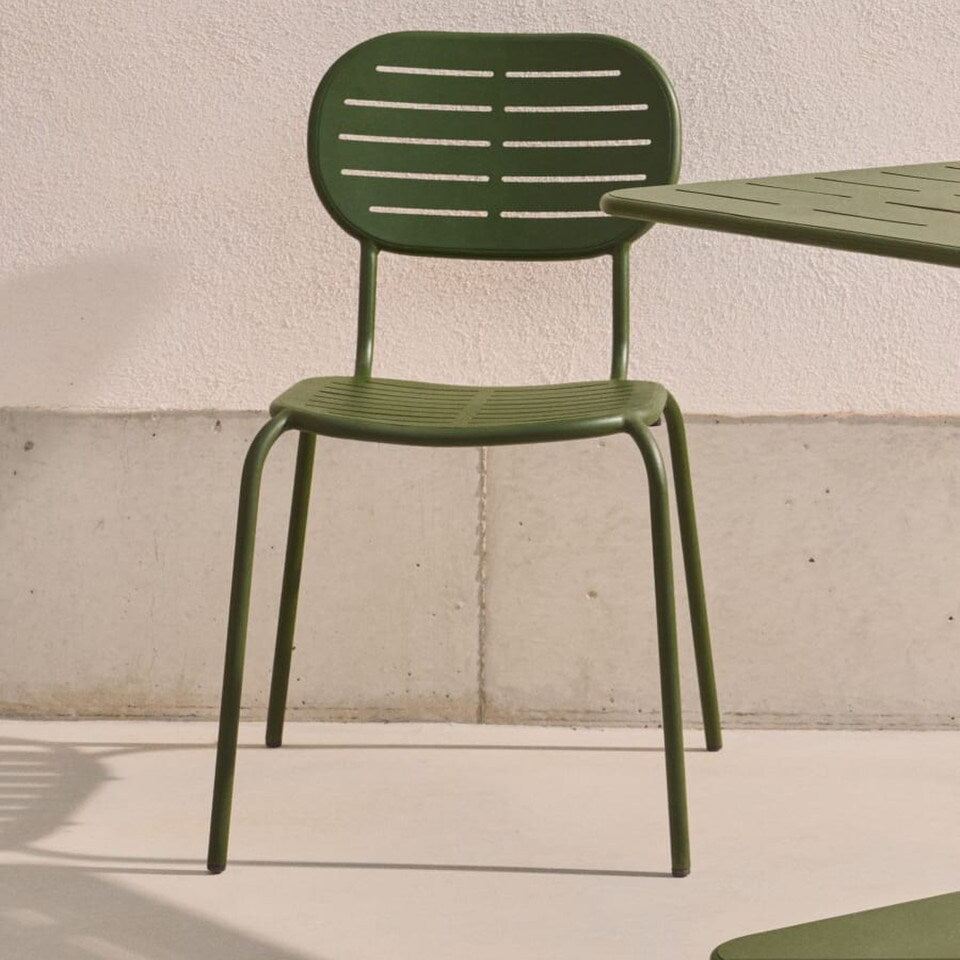 Green metal chair and table set against a light-coloured wall. Outdoor dining chair, stackable chairs. alfresco chairs