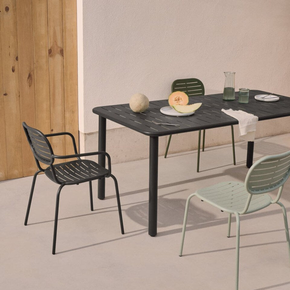 Outdoor dining setup with a black table and chairs on a neutral background. Outdoor chairs. Alfresco dining. 