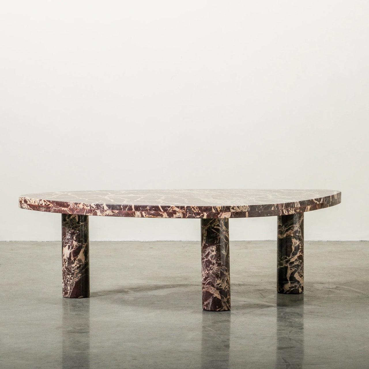 Cameo Stone Coffee Table in Cherry marble, rounded organic top on three column legs.