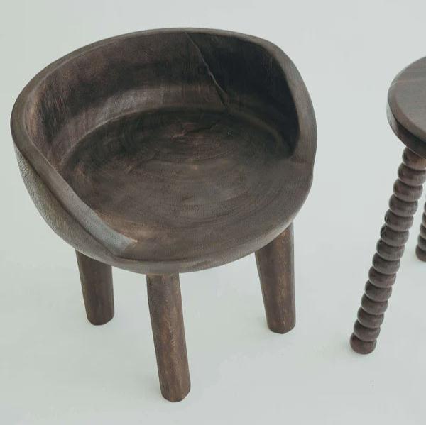 Carlos Chair in Walnut, carved rounded seat and backrest on three timber legs, shown on a white background.