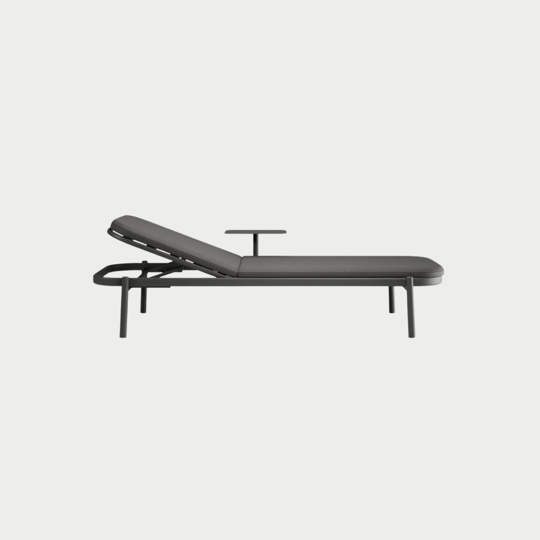 A modern outdoor chaise lounge chair with a dark gray cushioned frame and adjustable headrest, shown from a side angle against a light gray background.