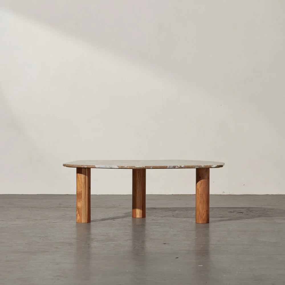 Clifton Table in Grey Lagoon marble, irregular rounded top on three acacia wood column legs.