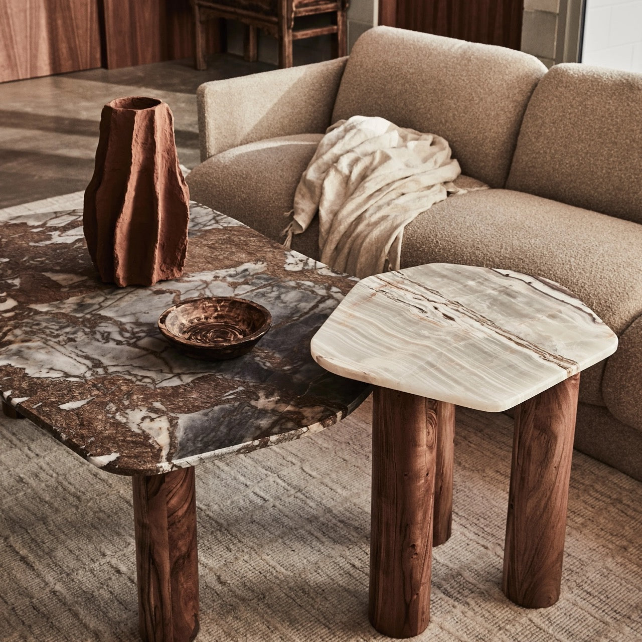 Clifton Table in Grey Lagoon marble, irregular rounded top on three acacia wood column legs.