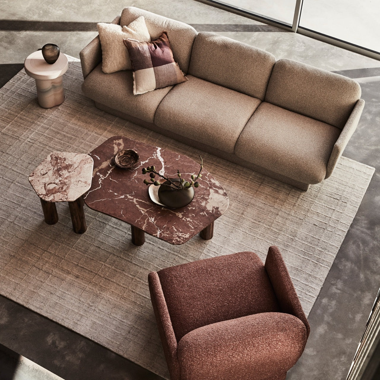 Clifton Table in Red Alicante marble, irregular rounded top on three acacia wood column legs.