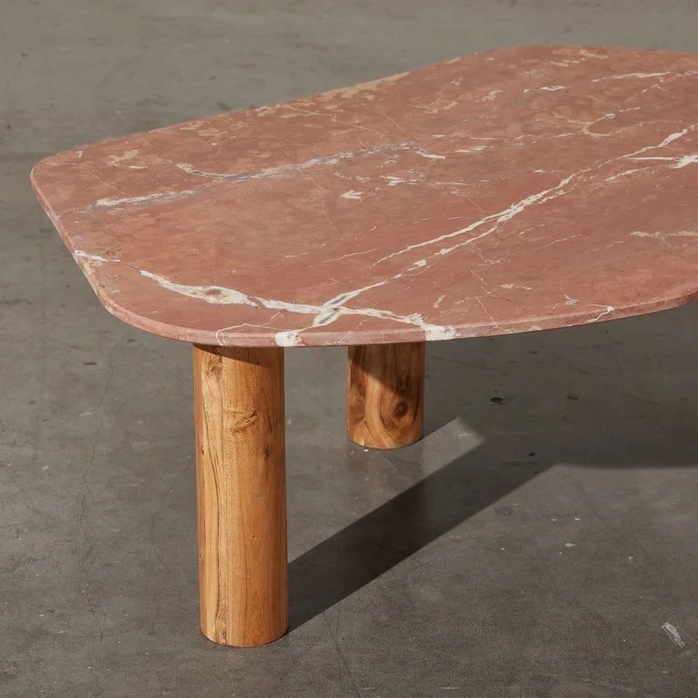 Clifton Table in Red Alicante marble, irregular rounded top on three acacia wood column legs.