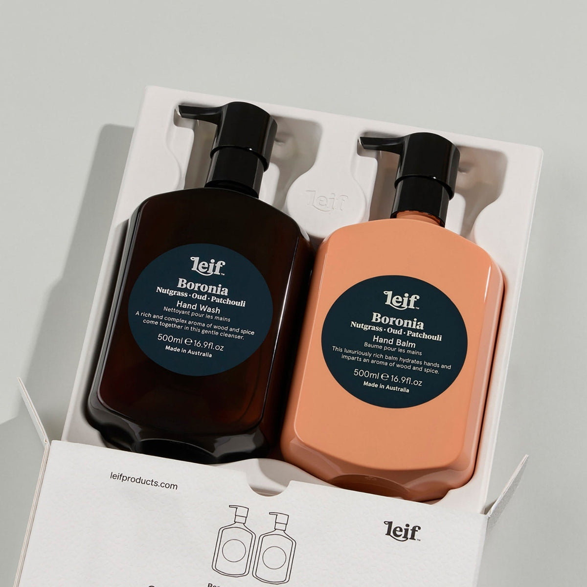 Leif Boronia Hand Wash and Hand Balm set in a white gift box, featuring a dark amber brown bottle and a peach-colored bottle with black pumps and dark blue circular labels.
