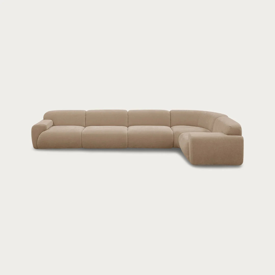 A modern curved modular sectional sofa upholstered in a textured beige fabric, shown from a low angle against a solid off-white background.