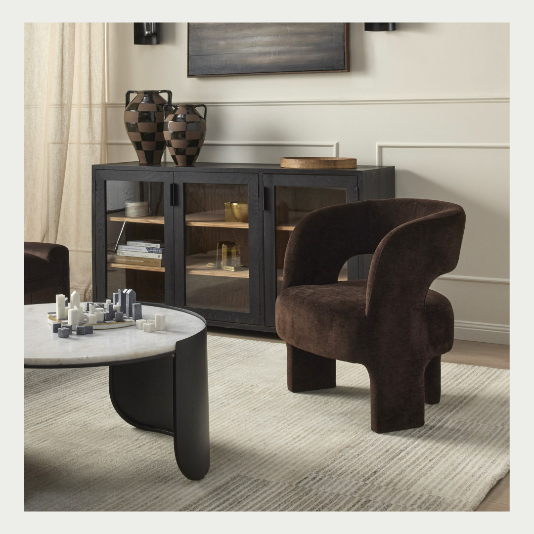 Formes Armchair in Chocolate velvet, curved cocoon backrest with an open cut-out and rounded plywood legs, styled in a living room.