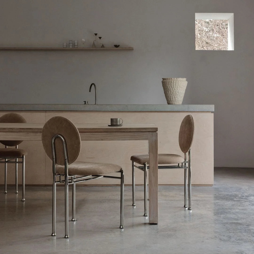 Dining chair with circular ecru upholstered backrest and steel legs