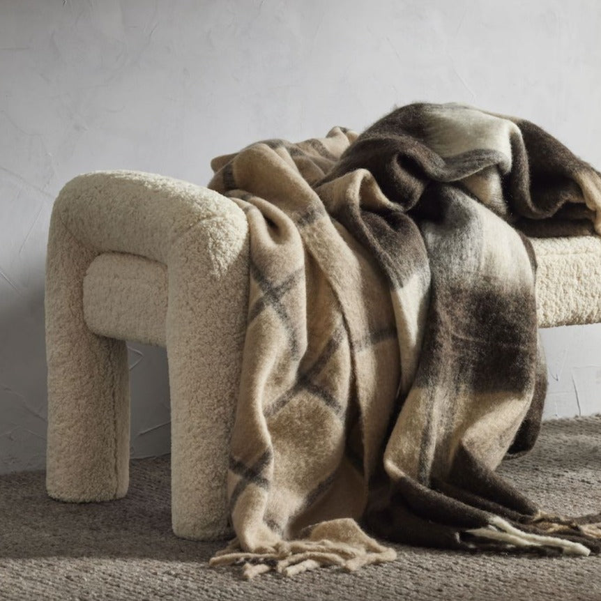 Mia Bench in off-white bouclé, rounded arm ends and chunky cylindrical legs, styled in a living room.