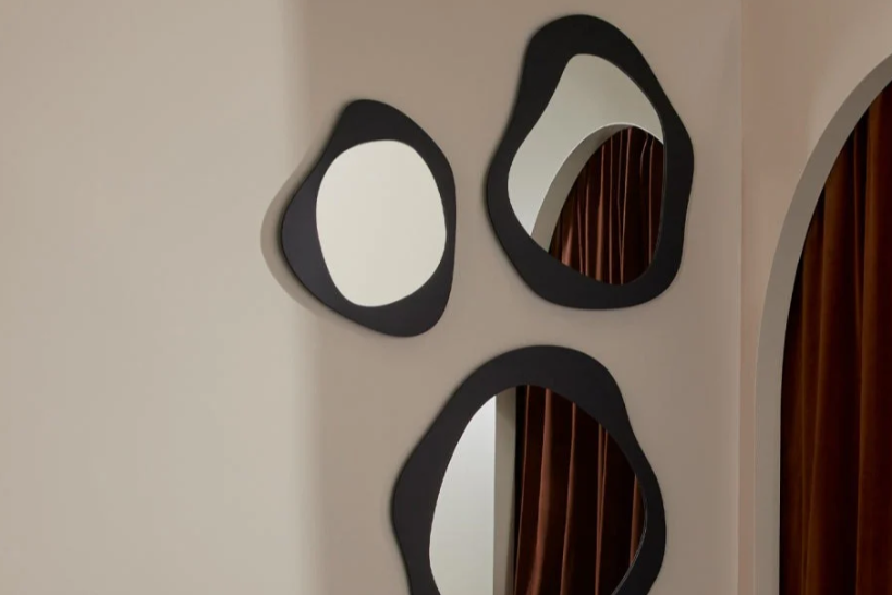 Three modern wall mirrors with black frames on a beige wall. Wall mirror. Hallway feature. Round mirror. Abstract mirror. 