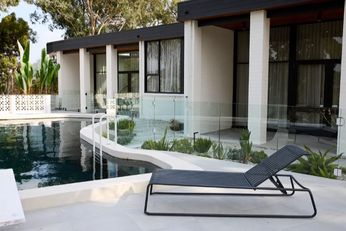 Modern house with a pool and lounge chair. stainless steel outdoor furniture. Aluminium or iron alfresco furniture