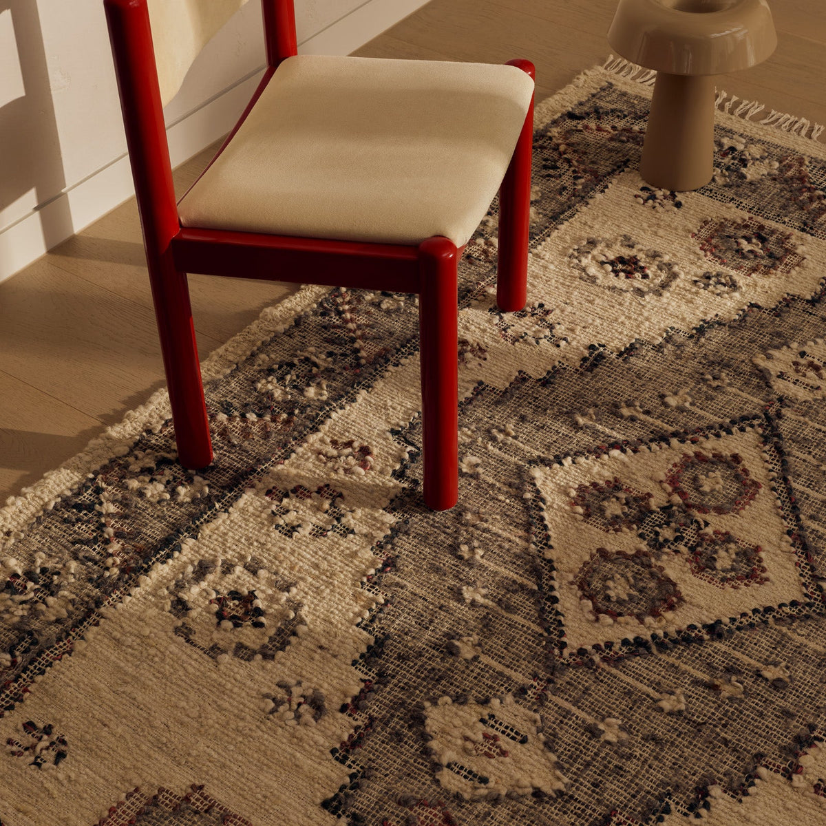 Tribe Home Ellora Rug in wool and jute with a central stepped charcoal diamond medallion, textured florets on a lichen-white field and a charcoal border with fringed ends