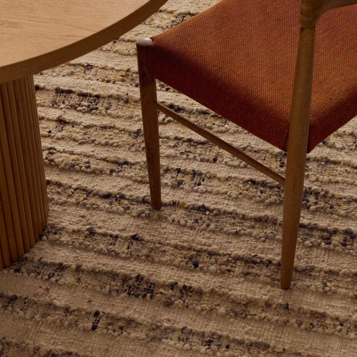 Tribe Home Tulsi Rug in Caraway with a textured cream wool and jute base and shifting linear bands in sage, khaki and taupe with fringed ends