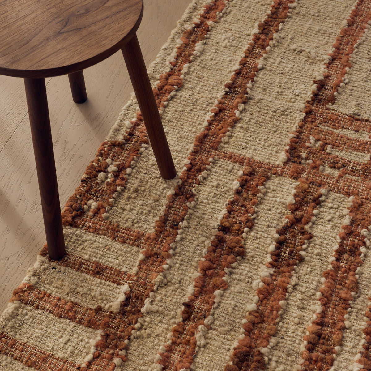 Tribe Home Tulsi Rug in Paprika with a textured cream wool and jute base and shifting linear stripes in terracotta and rust with fringed ends
