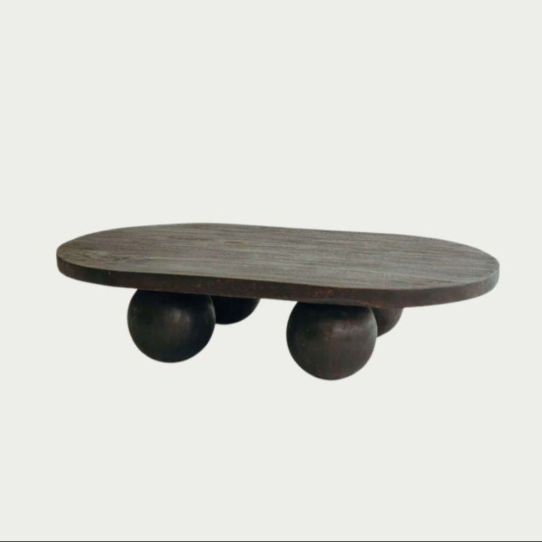 Valentina Table in Walnut suar timber, oval top on four rounded ball legs, shown on a plain studio backdrop.