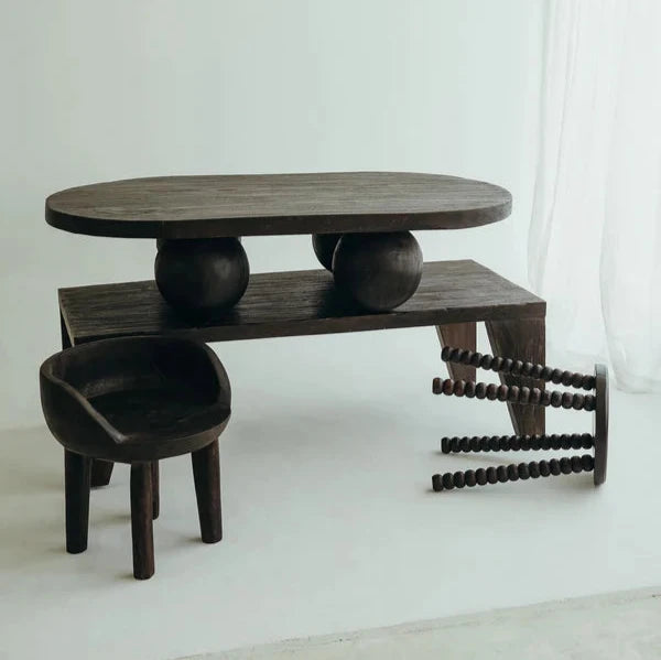 Valentina Table in Walnut suar timber, oval top on four rounded ball legs, shown on a plain studio backdrop.