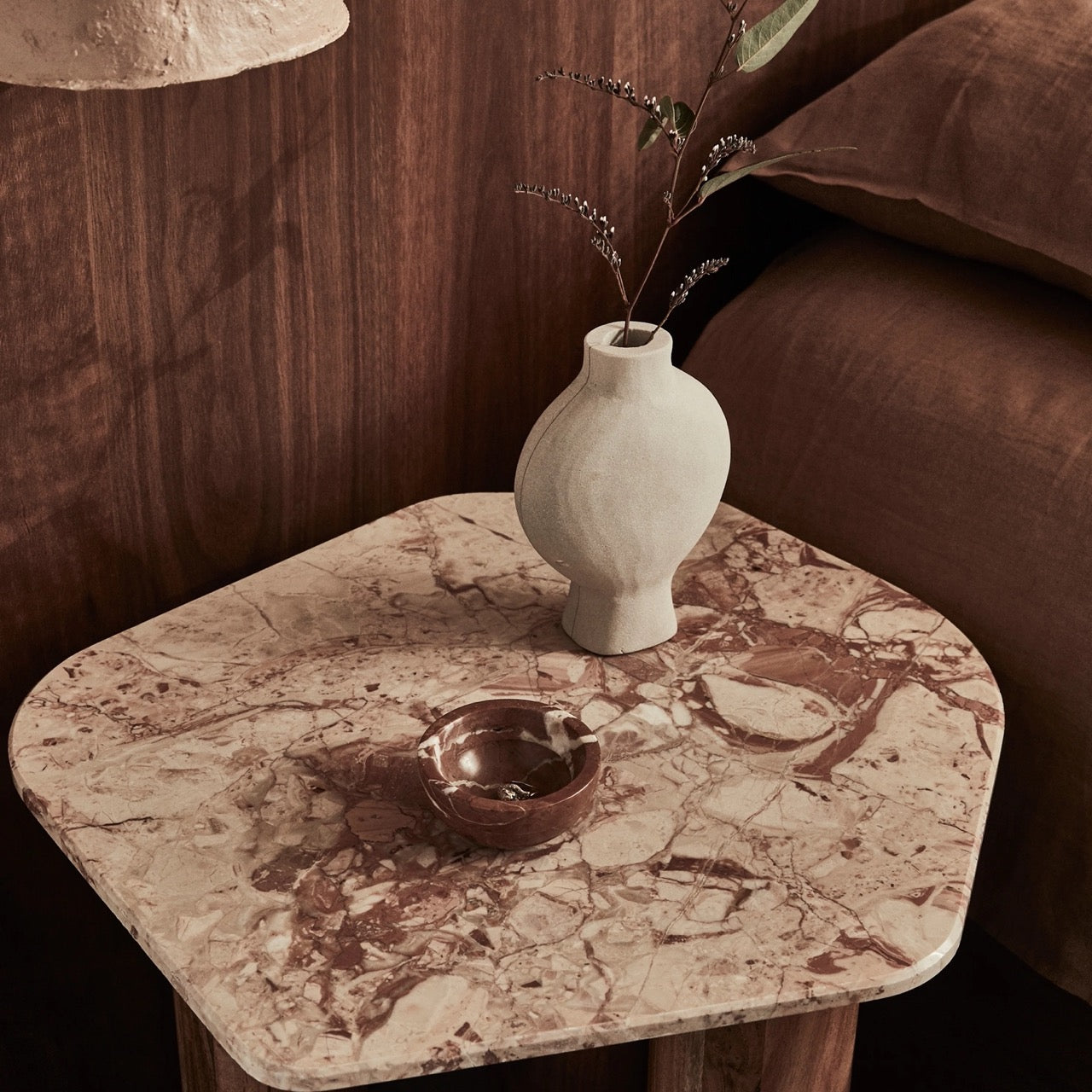 Waverly Side Table in Pink Lagoon marble, irregular rounded top on three wooden column legs.
