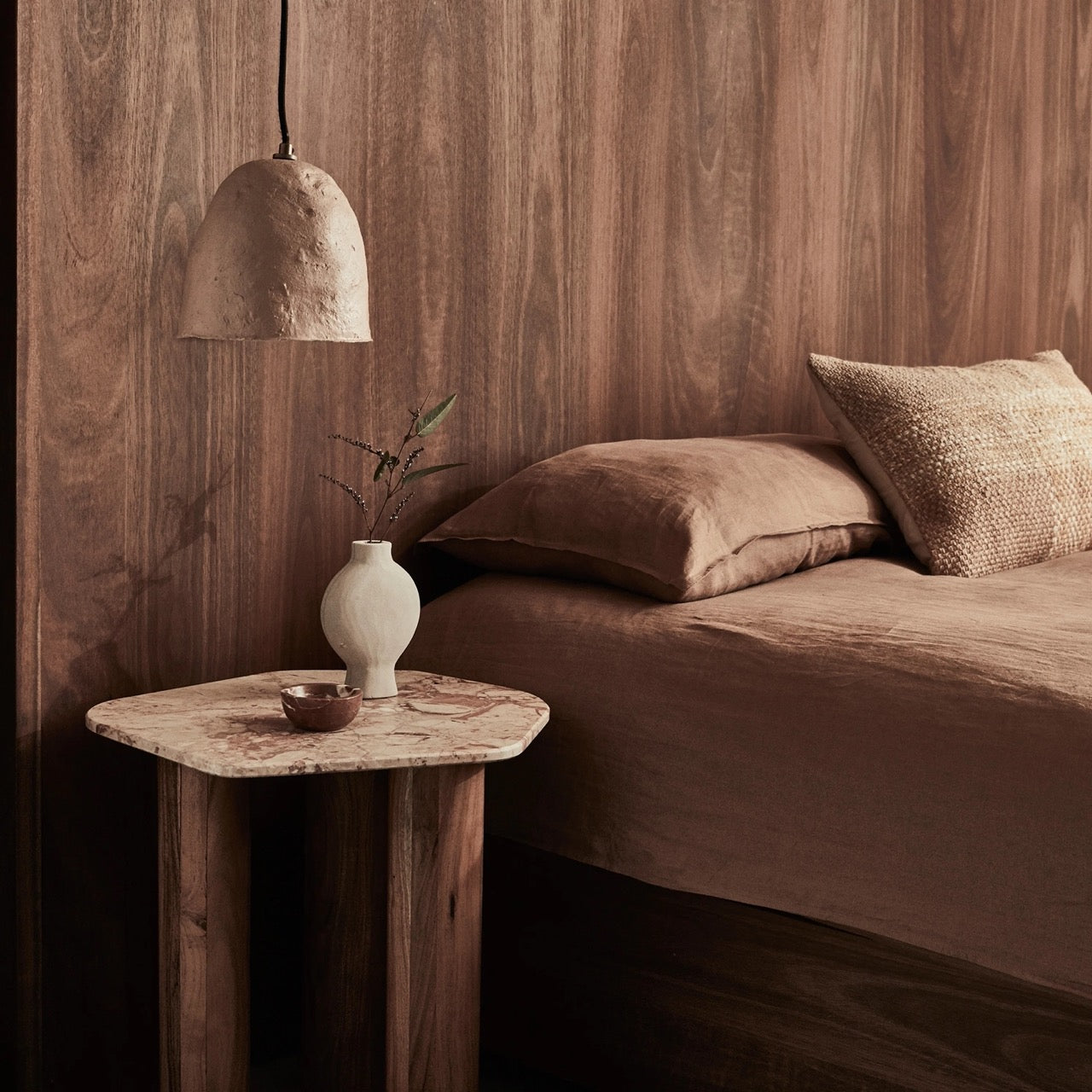 Waverly Side Table in Pink Lagoon marble, irregular rounded top on three wooden column legs.