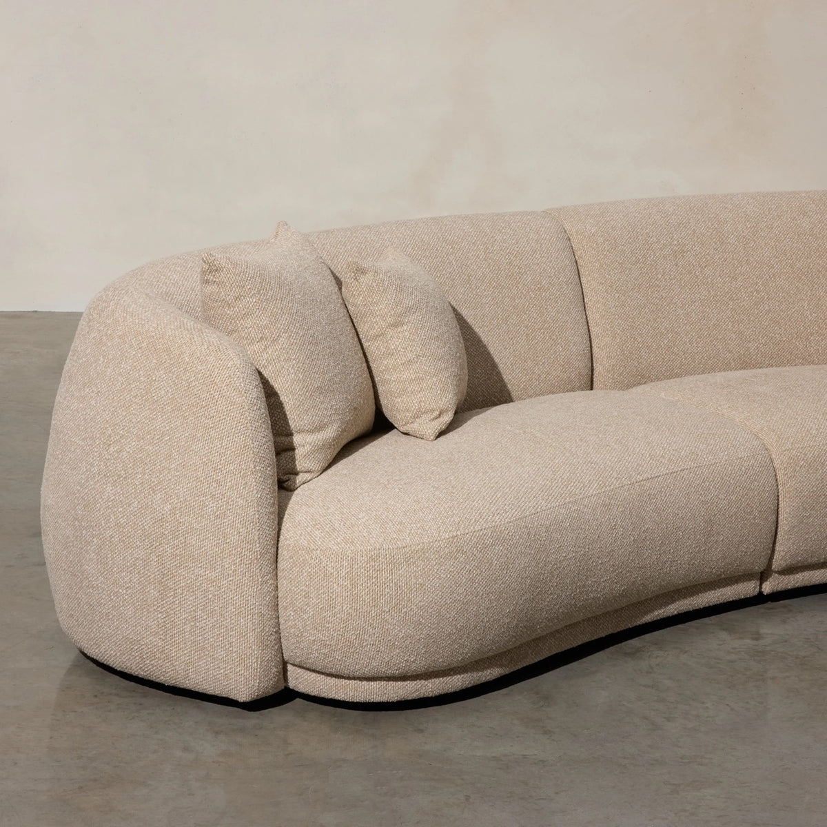 Ziggy Sofa in oatmeal bouclé, rounded pebble-like armrests and curved backrest.