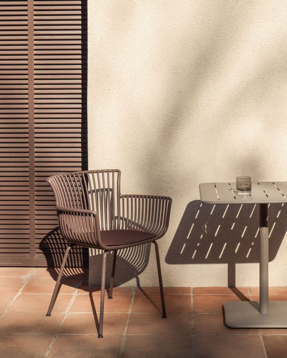 brown Alfresco chair with a hard wearing polypropylene structure, moulded arms, and powder coated steel legs.