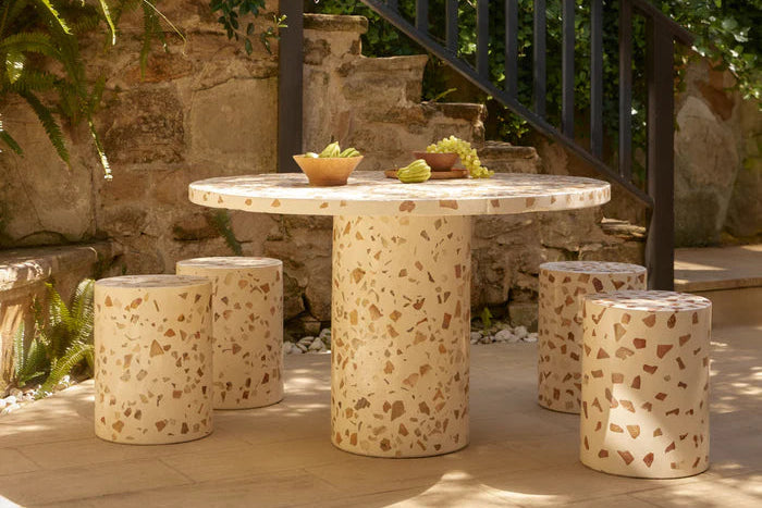 Outdoor setting with a stone table and stools under a tree. Outdoor dining table. Stone side table. Side table/stool