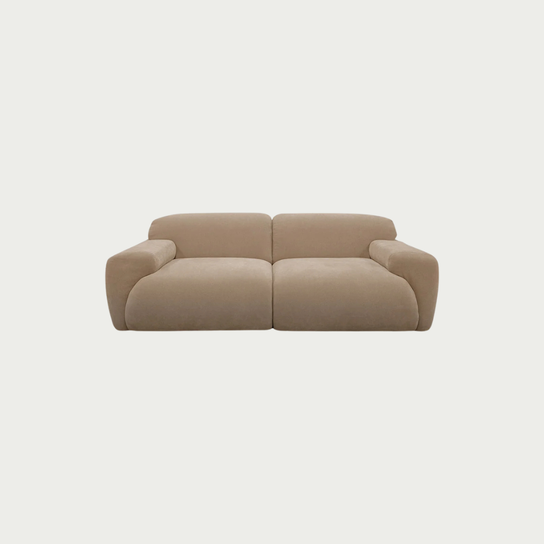 A modern two-seater sofa with rounded blocky arms and seat cushions, upholstered in a light beige fabric, shown against a solid off-white background.