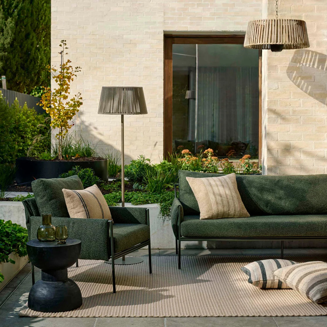 outdoor sofa and matching armchair in dark green for lounging in alfresco